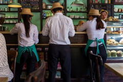 Hoi An Vietnam - April 20, 2018: Uppassaren och servitriers kontrollerar en beställning på en stång i Hoi An fotografering för bildbyråer Hoi An Vietnam - April 20, 2018: Uppassaren och servitriers kontrollerar en beställning på en stång i Hoi An fotografering för bildbyråer
