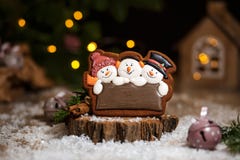 Holiday traditional food bakery. Gingerbread three fun snowmans in cozy warm decoration with garland lights royalty free stock photography Holiday traditional food bakery. Gingerbread three fun snowmans in cozy warm decoration with garland lights royalty free stock photography