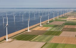 Holländskt landskap för flyg- sikt med turbiner för frånlands- vind längs kust royaltyfria bilder Holländskt landskap för flyg- sikt med turbiner för frånlands- vind längs kust royaltyfria bilder