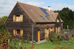 Holzhaus mit Sonnenkollektoren und Fensterläden Lizenzfreie Stockbilder Holzhaus mit Sonnenkollektoren und Fensterläden Lizenzfreie Stockbilder