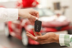 Hombre africano que recibe llaves del coche de dependienta imagen de archivo Hombre africano que recibe llaves del coche de dependienta imagen de archivo