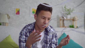 Hombre asiático joven ahorrado del calor que se incorpora delante de una fan de trabajo el concepto de cierre del calor almacen de video Hombre asiático joven ahorrado del calor que se incorpora delante de una fan de trabajo el concepto de cierre del calor almacen de video