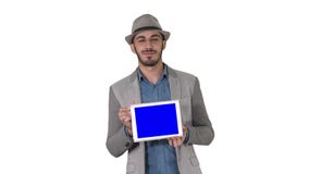Hombre casual en un sombrero que camina y que muestra la tableta digital a la cámara en el fondo blanco almacen de metraje de vídeo Hombre casual en un sombrero que camina y que muestra la tableta digital a la cámara en el fondo blanco almacen de metraje de vídeo