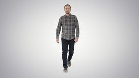 Hombre casual relajado en vaqueros y camisa que caminan y que miran a los lados en fondo de la pendiente almacen de video Hombre casual relajado en vaqueros y camisa que caminan y que miran a los lados en fondo de la pendiente almacen de video