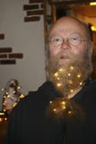 Hombre con vidrios y una cadena de luces, con las estrellas chispeantes en barba foto de archivo libre de regalías Hombre con vidrios y una cadena de luces, con las estrellas chispeantes en barba foto de archivo libre de regalías