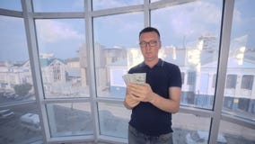Hombre confiado, sonriente que cuenta y que muestra el dinero, dólares de EE. UU. en cámara metrajes Hombre confiado, sonriente que cuenta y que muestra el dinero, dólares de EE. UU. en cámara metrajes