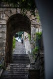 Hombre de funcionamiento en viejos pasos de la piedra de la ciudad fotografía de archivo libre de regalías Hombre de funcionamiento en viejos pasos de la piedra de la ciudad fotografía de archivo libre de regalías