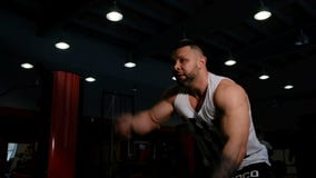 Hombre de la aptitud que hace un entrenamiento intenso usando cuerdas en un gimnasio El culturista muscular fuerte disfruta de un almacen de video Hombre de la aptitud que hace un entrenamiento intenso usando cuerdas en un gimnasio El culturista muscular fuerte disfruta de un almacen de video