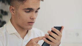 Hombre de negocios acertado joven usando el móvil elegante del teléfono para comprobar la notificación que lee la cara sorprendid metrajes Hombre de negocios acertado joven usando el móvil elegante del teléfono para comprobar la notificación que lee la cara sorprendid metrajes