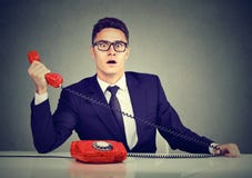 Hombre de negocios chocado que recibe malas noticias en el teléfono imagen de archivo libre de regalías Hombre de negocios chocado que recibe malas noticias en el teléfono imagen de archivo libre de regalías