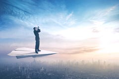 Hombre de negocios con los prismáticos en los aviones de papel Imágenes de archivo libres de regalías Hombre de negocios con los prismáticos en los aviones de papel Imágenes de archivo libres de regalías