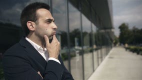 Hombre de negocios en cuestión hermoso que espera alguien al aire libre el edificio de oficinas almacen de metraje de vídeo Hombre de negocios en cuestión hermoso que espera alguien al aire libre el edificio de oficinas almacen de metraje de vídeo