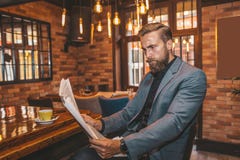 Hombre de negocios hermoso joven que lee un periódico fotografía de archivo libre de regalías Hombre de negocios hermoso joven que lee un periódico fotografía de archivo libre de regalías
