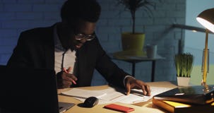 Hombre de negocios joven con el ordenador port?til y los papeles que trabajan tarde en la oficina de la noche Negocio, trabajoadi almacen de metraje de vídeo Hombre de negocios joven con el ordenador port?til y los papeles que trabajan tarde en la oficina de la noche Negocio, trabajoadi almacen de metraje de vídeo