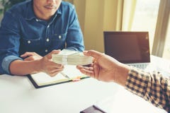 Hombre de negocios que da el dinero a su socio mientras que hace el contrato - imágenes de archivo libres de regalías Hombre de negocios que da el dinero a su socio mientras que hace el contrato - imágenes de archivo libres de regalías