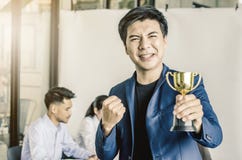 Hombre de negocios que lleva a cabo el premio del trofeo para el éxito en negocio, fotografía de archivo libre de regalías Hombre de negocios que lleva a cabo el premio del trofeo para el éxito en negocio, fotografía de archivo libre de regalías