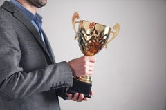 Hombre de negocios que sostiene el trofeo de oro Negocio, ?xito imágenes de archivo libres de regalías Hombre de negocios que sostiene el trofeo de oro Negocio, ?xito imágenes de archivo libres de regalías
