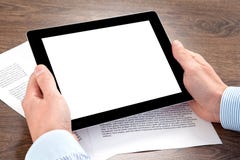 Hombre de negocios que sostiene una tableta en la tabla con los documentos imagenes de archivo Hombre de negocios que sostiene una tableta en la tabla con los documentos imagenes de archivo