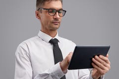 Hombre de negocios serio usando la tableta imagenes de archivo Hombre de negocios serio usando la tableta imagenes de archivo