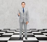 Hombre de negocios sonriente feliz en el traje que sacude la mano fotos de archivo libres de regalías Hombre de negocios sonriente feliz en el traje que sacude la mano fotos de archivo libres de regalías
