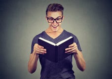 Hombre emocionado que mira el libro fotografía de archivo Hombre emocionado que mira el libro fotografía de archivo