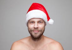 Hombre hermoso con la barba que lleva un sombrero de la Navidad Imágenes de archivo libres de regalías Hombre hermoso con la barba que lleva un sombrero de la Navidad Imágenes de archivo libres de regalías