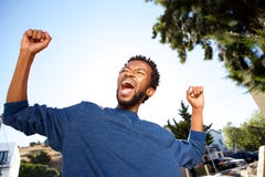 Hombre hermoso extático que celebra con los brazos extendidos fotos de archivo Hombre hermoso extático que celebra con los brazos extendidos fotos de archivo