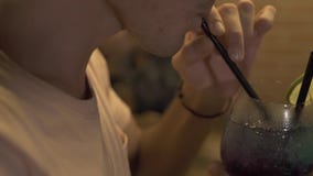 Hombre hermoso que bebe el cóctel alcohólico de la paja en el contador de la barra en la igualación del pub Cierre encima del cóc metrajes Hombre hermoso que bebe el cóctel alcohólico de la paja en el contador de la barra en la igualación del pub Cierre encima del cóc metrajes