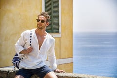 Hombre hermoso que se sienta en la ciudad de la playa imagenes de archivo Hombre hermoso que se sienta en la ciudad de la playa imagenes de archivo
