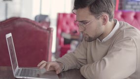 Hombre hermoso que trabaja con el ordenador portátil en cierre moderno del café para arriba Hombre de negocios confiado elegante metrajes Hombre hermoso que trabaja con el ordenador portátil en cierre moderno del café para arriba Hombre de negocios confiado elegante metrajes