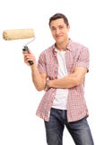 Hombre joven alegre que sostiene un rodillo de pintura fotos de archivo libres de regalías Hombre joven alegre que sostiene un rodillo de pintura fotos de archivo libres de regalías