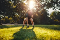 Hombre joven apto que ejercita con el kettlebell al aire libre Foto de archivo libre de regalías Hombre joven apto que ejercita con el kettlebell al aire libre Foto de archivo libre de regalías