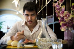 Hombre joven hermoso que almuerza en restaurante elegante foto de archivo Hombre joven hermoso que almuerza en restaurante elegante foto de archivo
