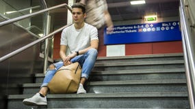 Hombre joven hermoso que se sienta en las escaleras imagen de archivo Hombre joven hermoso que se sienta en las escaleras imagen de archivo
