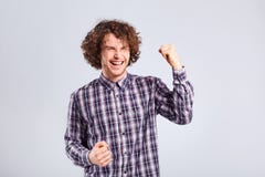 Hombre joven rizado sorprendido, emoción alegre en su cara imagen de archivo Hombre joven rizado sorprendido, emoción alegre en su cara imagen de archivo