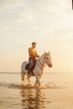 Hombre machista y caballo en el fondo del cielo y del agua Modo del muchacho fotos de archivo Hombre machista y caballo en el fondo del cielo y del agua Modo del muchacho fotos de archivo