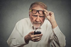 Hombre mayor con los vidrios que tienen problema que ve el teléfono celular Hombre mayor con los vidrios que tienen problema que ve el teléfono celular