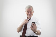 Hombre mayor que sonríe en un teléfono móvil imagenes de archivo Hombre mayor que sonríe en un teléfono móvil imagenes de archivo