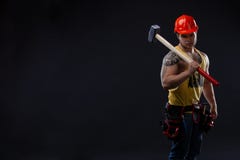 Hombre muscular brutal del trabajador con un martillo fotos de archivo Hombre muscular brutal del trabajador con un martillo fotos de archivo