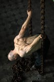 Hombre muscular en encadenamientos Fotografía de archivo Hombre muscular en encadenamientos Fotografía de archivo