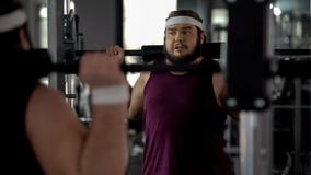 Hombre obeso que hace apenas el ejercicio con el barbell en gimnasio, entrenamiento de la aptitud, deporte imagen de archivo Hombre obeso que hace apenas el ejercicio con el barbell en gimnasio, entrenamiento de la aptitud, deporte imagen de archivo