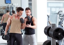 Hombre personal del amaestrador de la gimnasia con el entrenamiento del peso imagen de archivo Hombre personal del amaestrador de la gimnasia con el entrenamiento del peso imagen de archivo