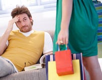 Hombre preocupado y mujer shopaholic Imagen de archivo Hombre preocupado y mujer shopaholic Imagen de archivo