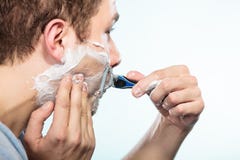 Hombre que afeita con perfil de la cara de la maquinilla de afeitar Imágenes de archivo libres de regalías Hombre que afeita con perfil de la cara de la maquinilla de afeitar Imágenes de archivo libres de regalías