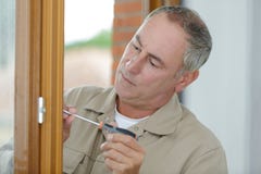 Hombre que atornilla y que repara el tirador de puerta fotos de archivo Hombre que atornilla y que repara el tirador de puerta fotos de archivo