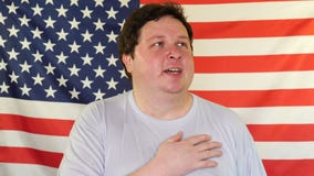 Hombre que canta el himno americano nacional en el fondo de una bandera de los E.E.U.U. metrajes Hombre que canta el himno americano nacional en el fondo de una bandera de los E.E.U.U. metrajes