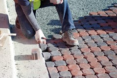 Hombre que coloca piedras de pavimentación Hombre que coloca piedras de pavimentación