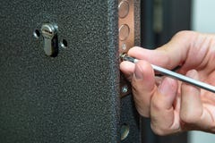 Hombre que fija la puerta con destornillador Reparación de la cerradura de puerta imagen de archivo Hombre que fija la puerta con destornillador Reparación de la cerradura de puerta imagen de archivo
