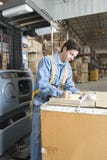 Hombre que hace notas en Warehouse imágenes de archivo libres de regalías Hombre que hace notas en Warehouse imágenes de archivo libres de regalías