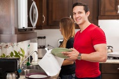 Hombre que hace platos con su muchacha imágenes de archivo libres de regalías Hombre que hace platos con su muchacha imágenes de archivo libres de regalías